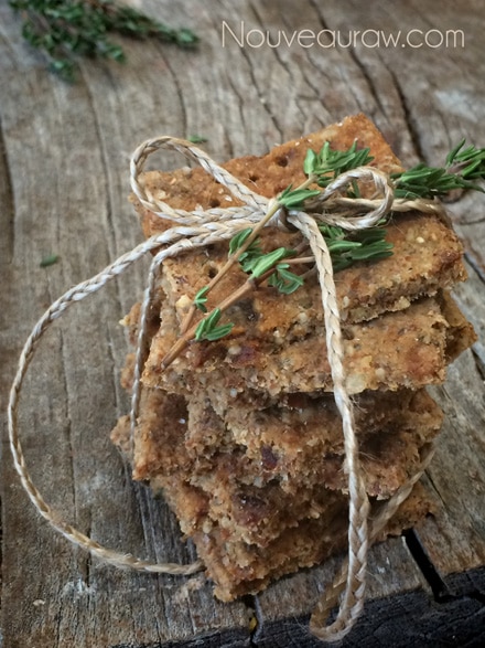 a stack of raw vegan gluten free Thyme and Pecan Coastal Crackers with fresh rosemary