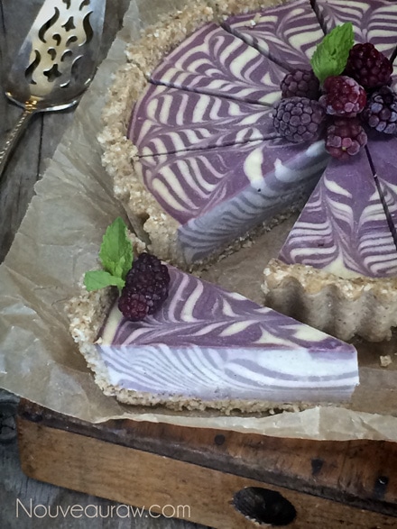 removing a slice of a top view of my Raw vegan Vanilla Bean and Blackberry Zebra Swirl Cheesecake 