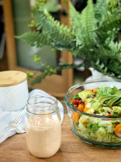 Russian-Salad-Dressing on a wooden table with a fresh salad