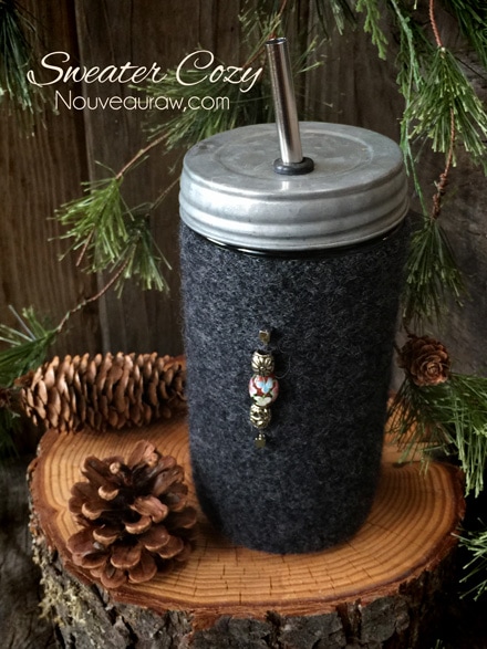 a wool sweater sleeve used to make a jar cozy with a straw lid on it, decorated with beads
