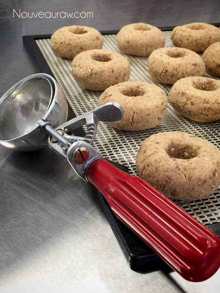 using an old fashion ice cream scoop to measure out the raw vegan gluten-free Old Fashioned Apple Spiced Doughnuts