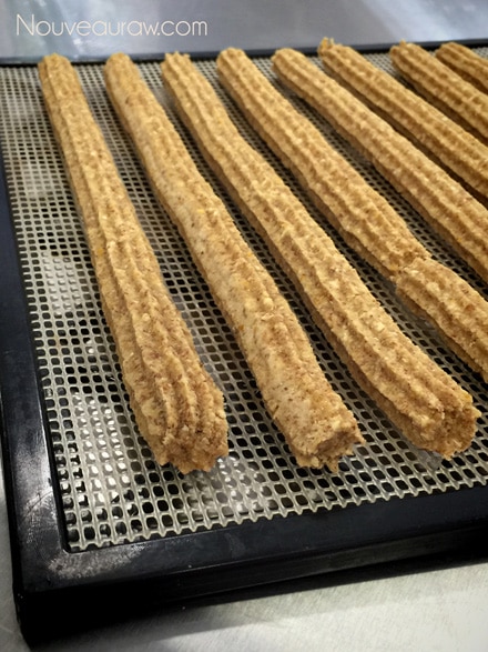 raw vegan gluten free Churro Pastries piped out on the dehydrator tray noting their color change as they dry
