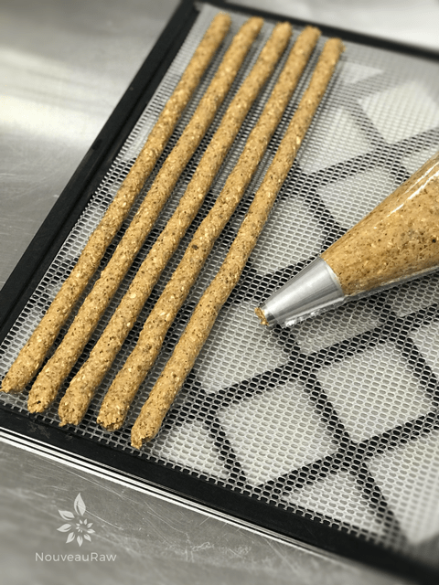 Granola-Crunch'Ola-Cereal batter piped on a dehydrator tray