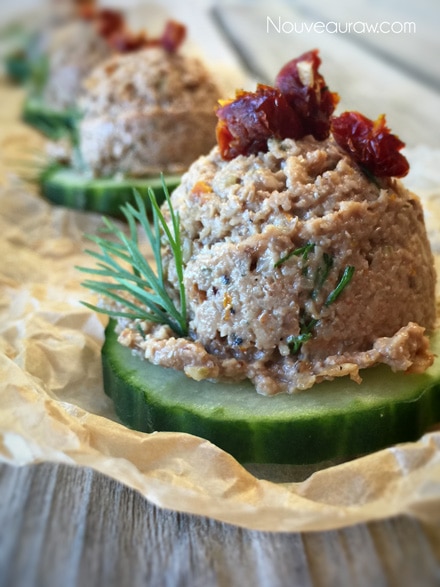 close up of raw vegan gluten-free Sun-Dried Tomato Pate & Cucumber Canapés served on parchment paper