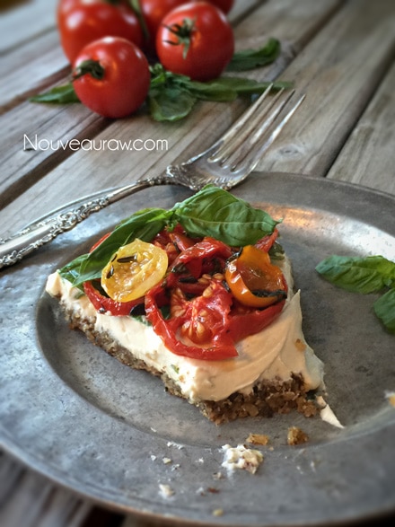 single serving of the raw vegan Caprese Herb and Tomato Tart displayed on a wooden table