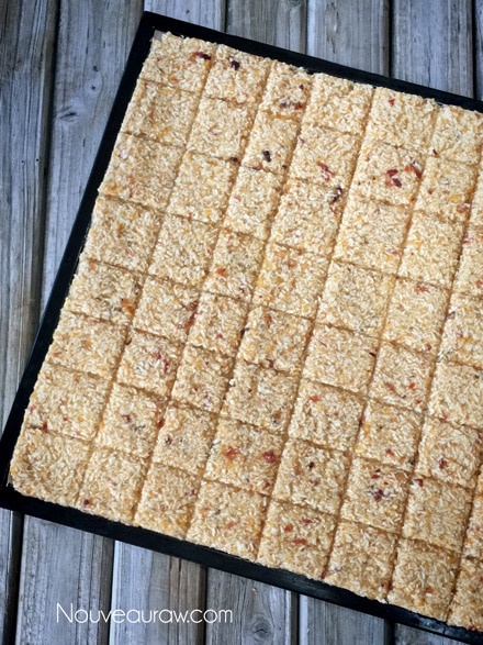 Dehydrated and scored raw Cinnamon Peach Coconut Crackers in a tray 