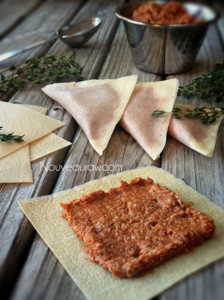 creating the raw vegan Pizza Ravioli by spreading the filling on the coconut wrap