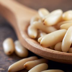 pine nuts on a wooden spoon close up