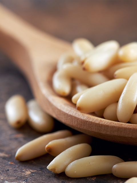 pine nuts on a wooden spoon close up