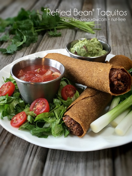 raw vegan gluten free “Refried Bean" Taquitos served on a plate with a fresh salad