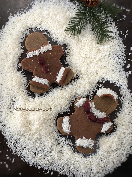 Hum Mud Gingerbread Men cookies shaped into gingerbread men making snow angels in shredded coconut