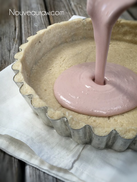 pouring the cultured cheesecake into the nut crust