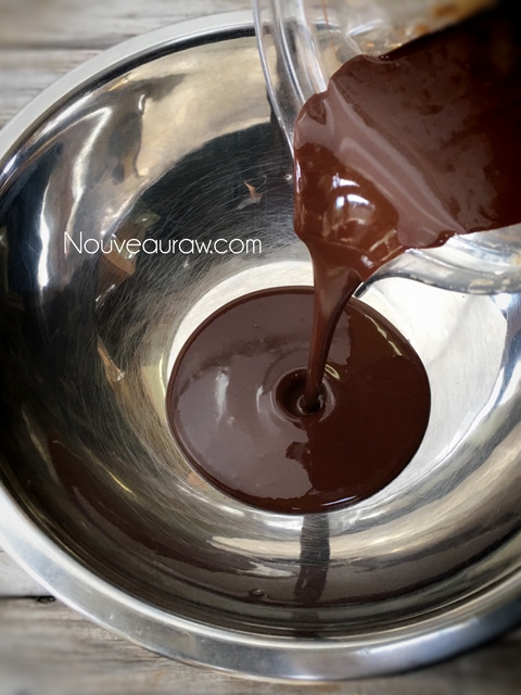 pouring raw milk chocolate into a stainless steel bowl