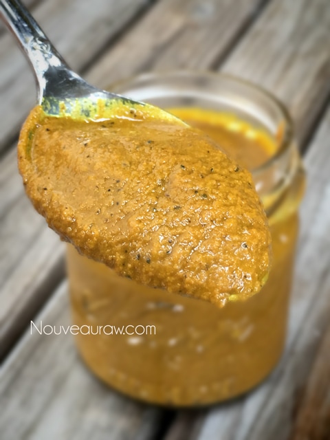 a close up spoonful of Golden Turmeric Paste in a mason jar great for inflammation