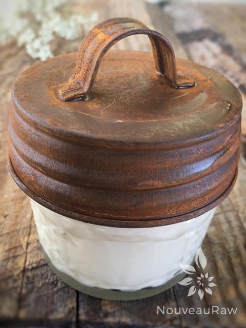 a close up Sweet Almond and Orange Body Butter in a small mason jar with a rustic lid