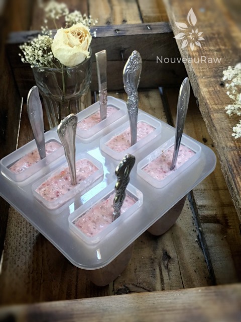 pour the raw vegan Strawberry Rhubarb Coconut Chia Popsicles in the molds and add spoons