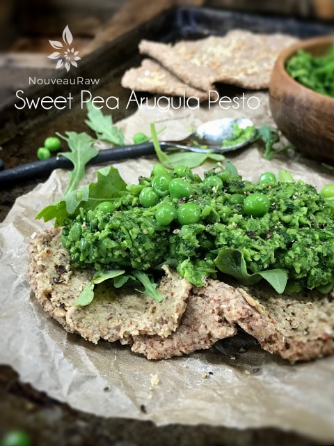 raw vegan Sweet Pea Arugula Pesto on a raw cracker