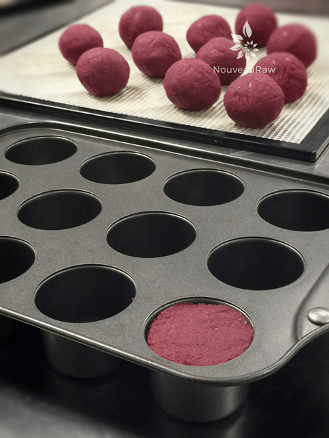 Pressing the red velvet cupcake dough into the pan to shape them