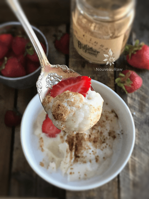 a spoonful of vegan grain-free Sweet Cauliflower Porridge served with fresh strawberries
