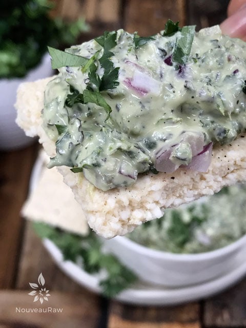 a close up of raw vegan Creamy Kale Dip on a cracker