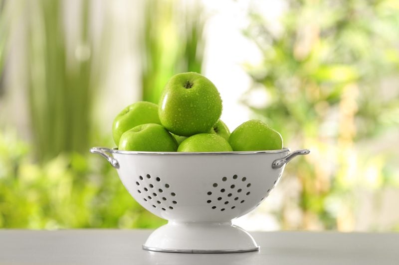 green apples in a white colander 
