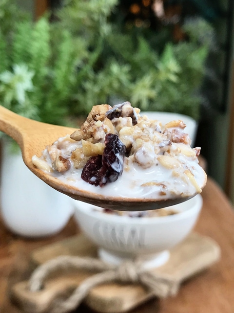 maple-nut-and-cranberry-muesli on a wooden spoon