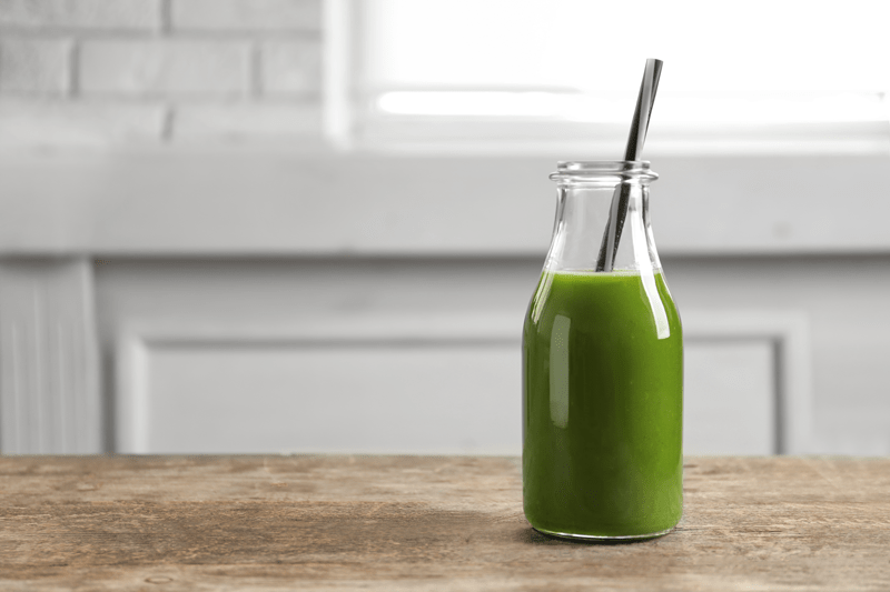 Green-juice-in-bottle-on-wooden-counter-top-800